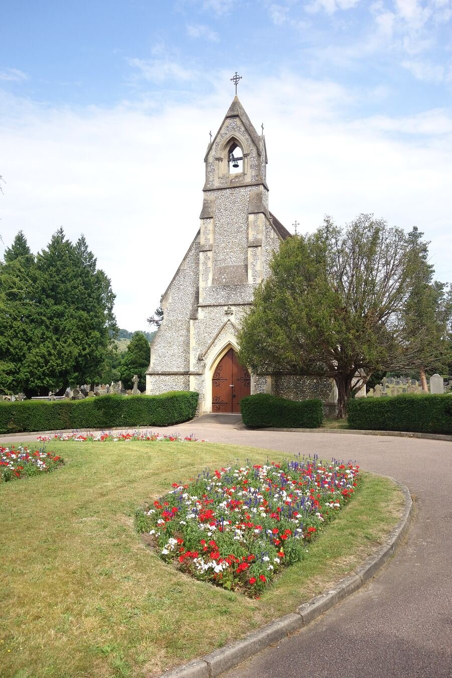 A small cemetery chapel with a tended flower bed in front of it